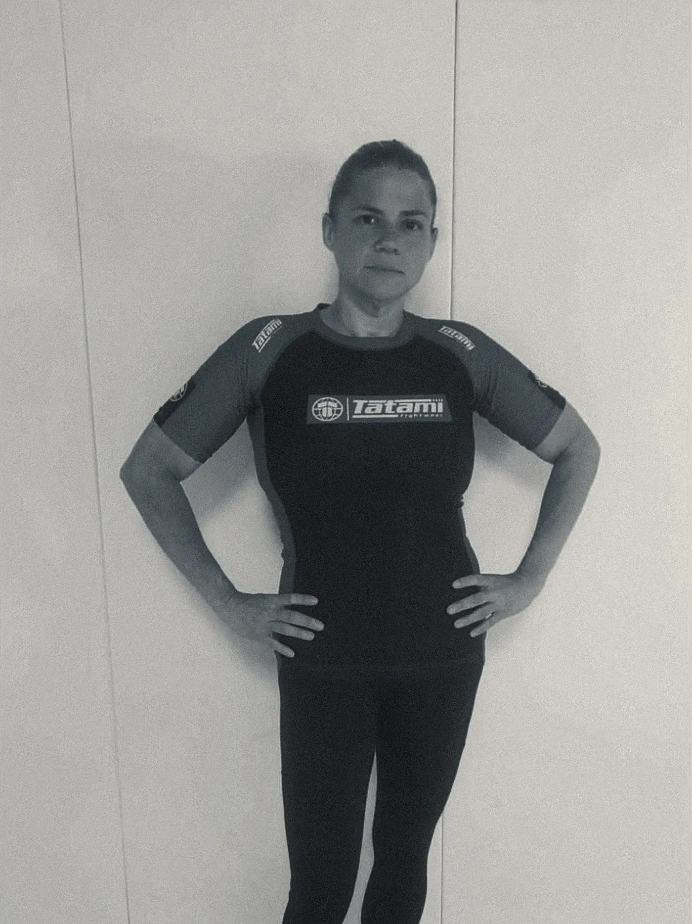 The same client afterwards in a grappling rashguard and leggings, visibly leaner and stronger